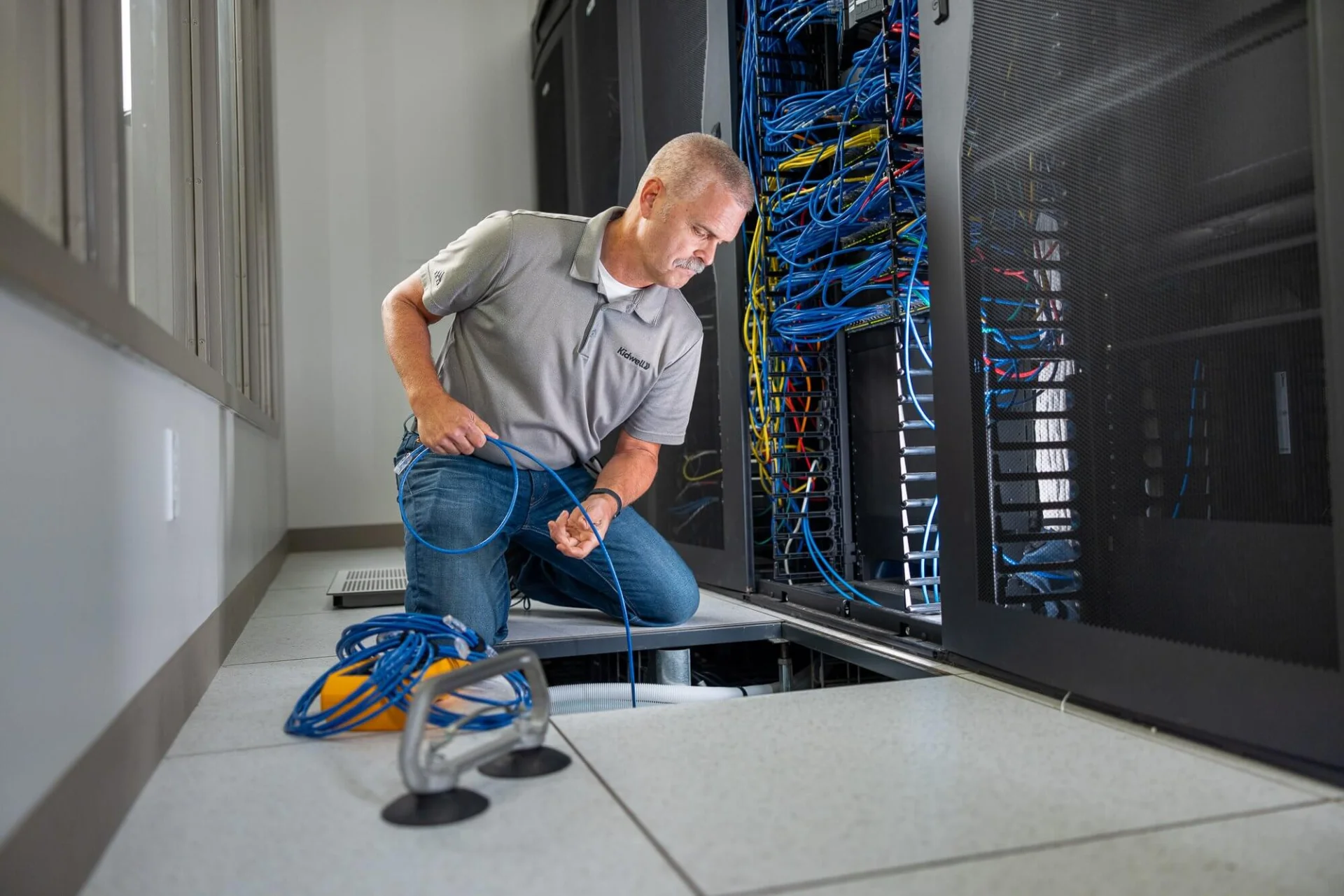 DigiCo technician working at a network rack on a Los Angeles data cabling project